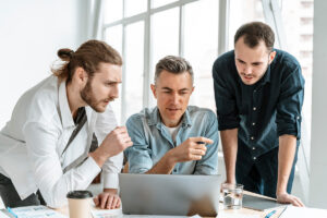 a group of men looking at a laptop